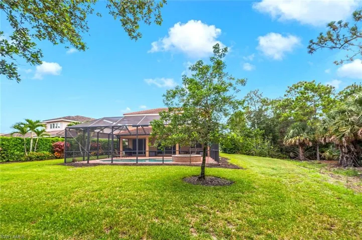 View of green lawn featuring an outdoor pool and a lanai