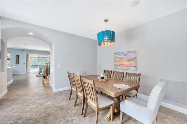 Dining room featuring arched walkways and baseboards