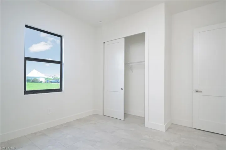 Unfurnished bedroom featuring a closet and light tile flooring