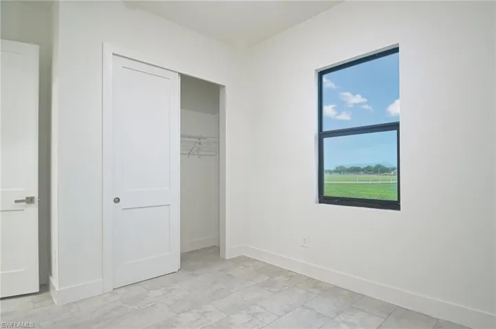 Unfurnished bedroom with a closet and light tile flooring