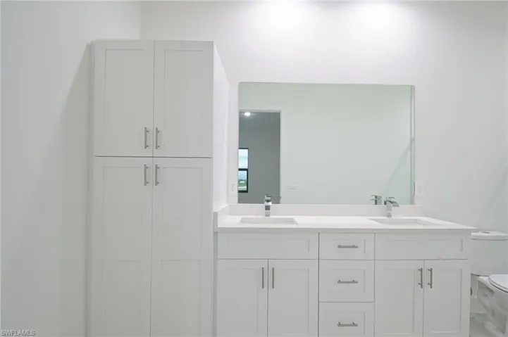 Bathroom featuring double vanity and toilet