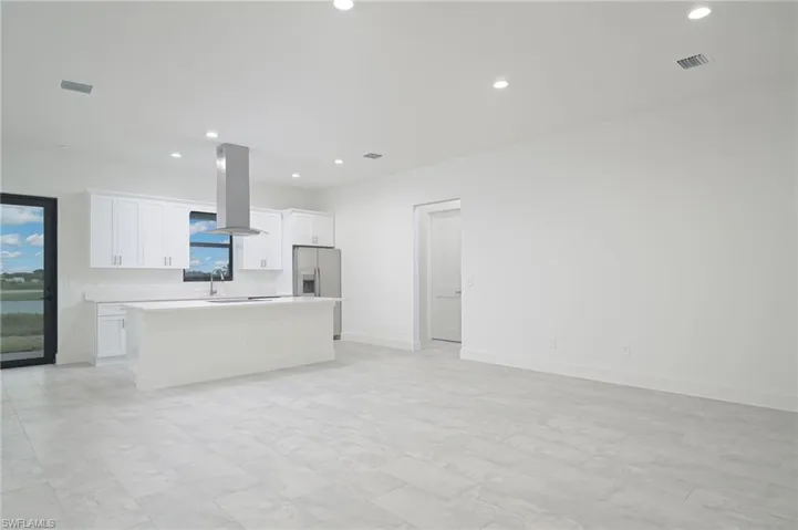 Kitchen featuring a center island, white cabinetry, stainless steel fridge with ice dispenser, island exhaust hood, and light tile floors