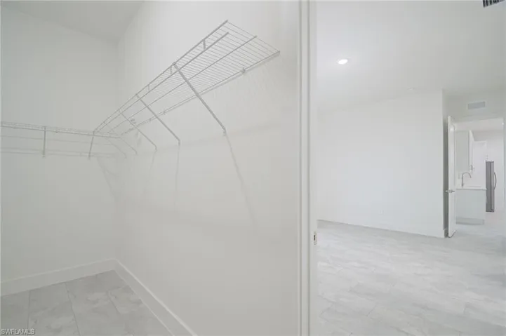 Walk in closet featuring light tile floors