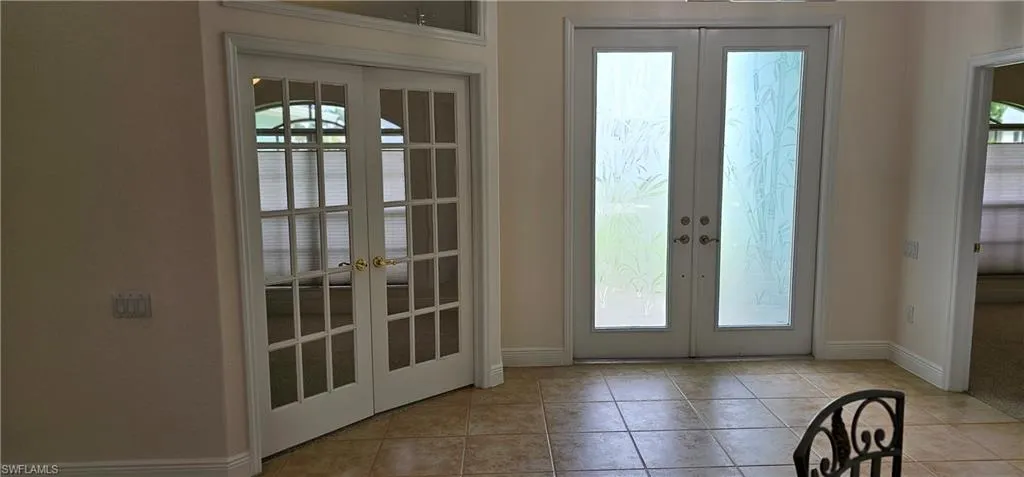 Doorway to outside featuring french doors and light tile patterned floors