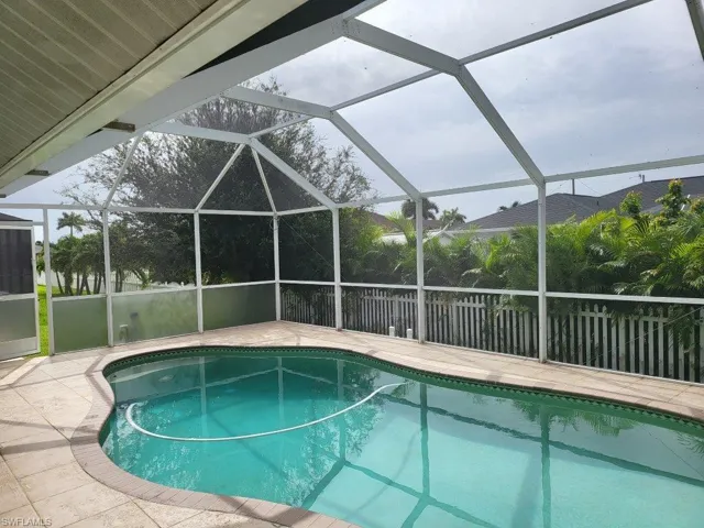 View of swimming pool with a patio and glass enclosure