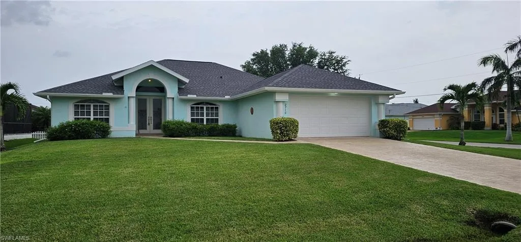 Single story home featuring a garage and a front lawn