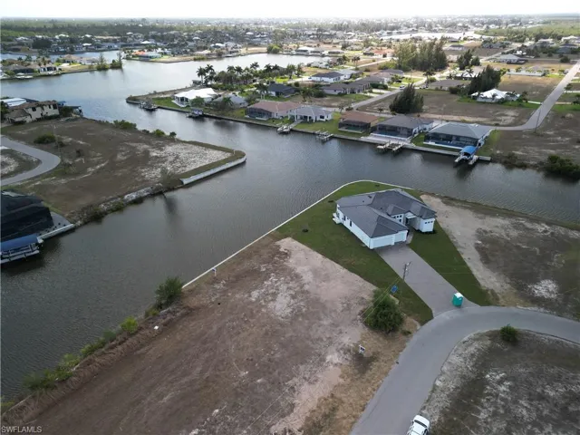 Aerial overview of property's location featuring a nearby body of water and nearby suburban area