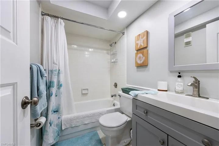 Full bathroom featuring vanity, shower / bathtub combination with curtain, and recessed lighting