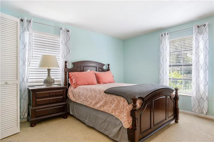 Bedroom with light colored carpet and baseboards