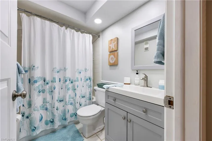 Full bathroom with vanity, a shower with shower curtain, recessed lighting, and light tile patterned floors