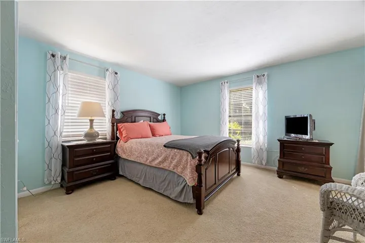 Bedroom featuring light carpet and baseboards