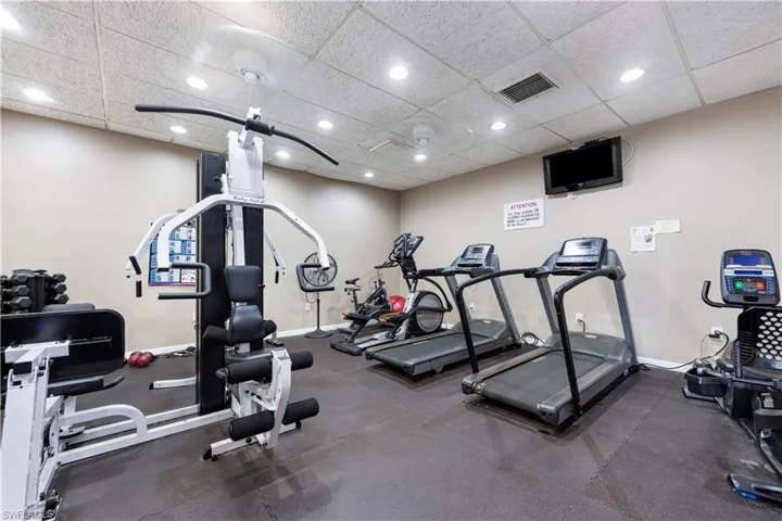 Gym featuring a paneled ceiling and recessed lighting