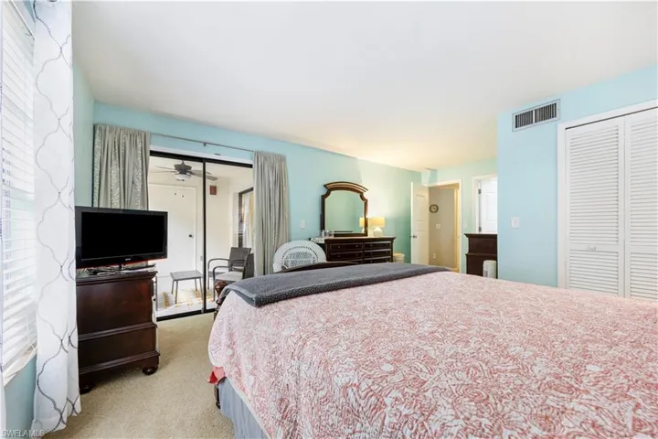 Bedroom featuring light colored carpet, a closet, and access to outside