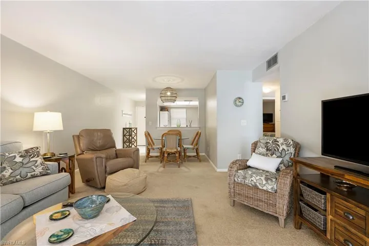 Living area featuring light carpet and baseboards
