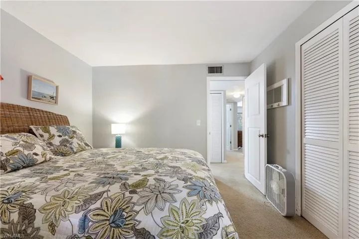 Bedroom with light colored carpet and a closet