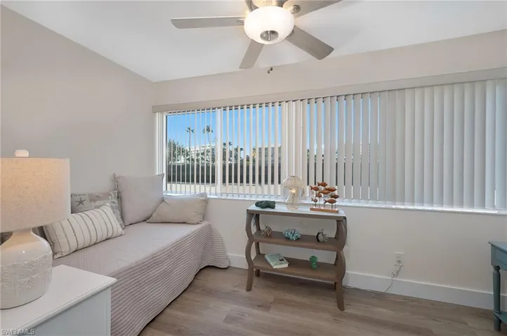 Sitting room featuring vaulted ceiling, ceiling fan, baseboards, and wood finished floors