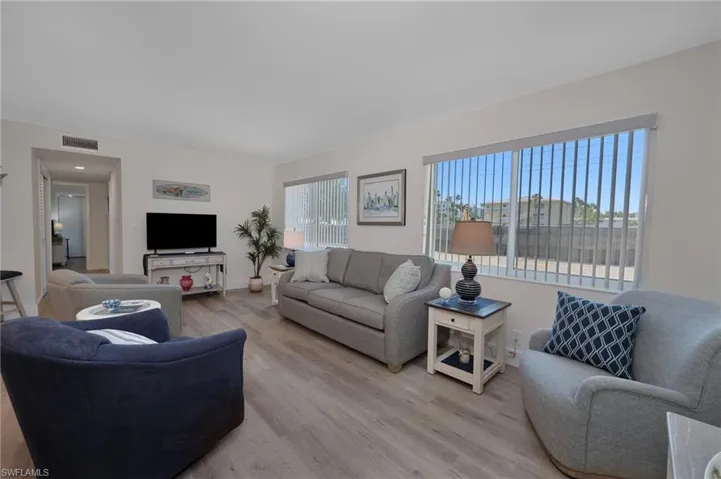 Living area with light wood-style flooring and visible vents