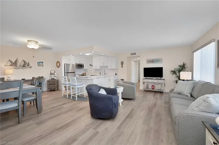 Living area featuring light wood-type flooring, a ceiling fan, visible vents, and recessed lighting