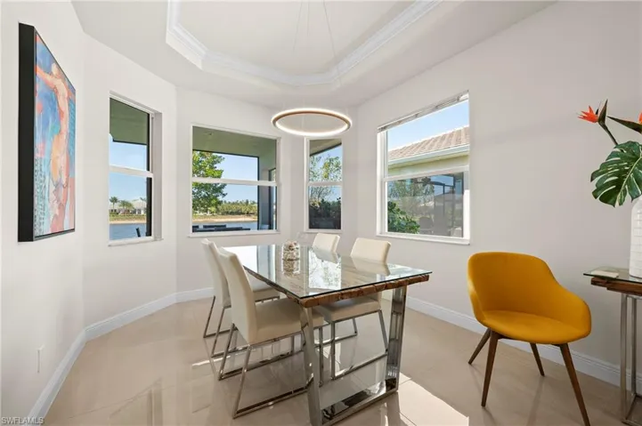 Dining area with plenty of natural light, ornamental molding, and a raised ceiling