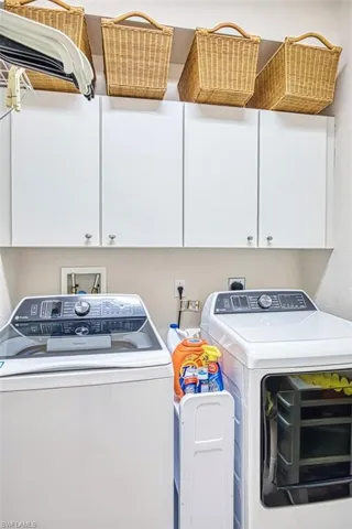 Washroom featuring washer and dryer and cabinet space
