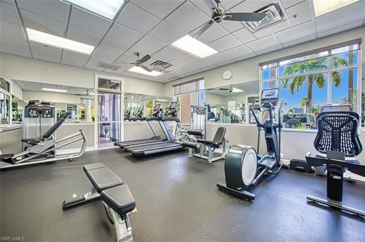 Workout area featuring a ceiling fan and a paneled ceiling