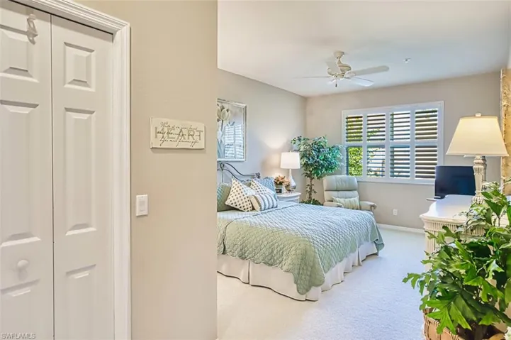 Carpeted bedroom with baseboards and a ceiling fan