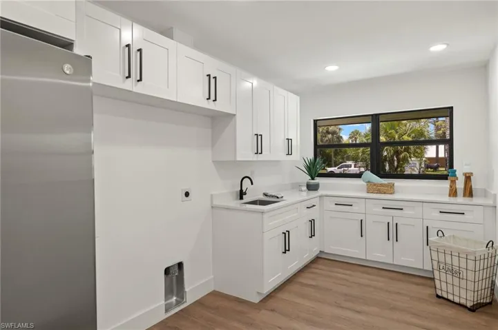 This Laundry Room has a Full Size Fridge, a ton of Cabinets and Counter Space