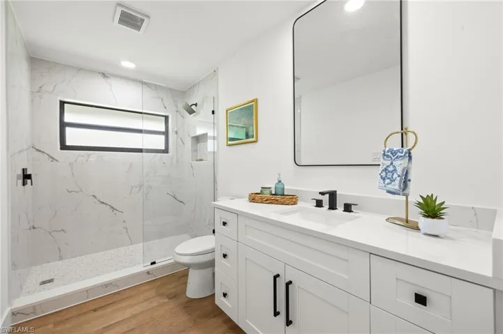 The Guest Ensuite Bathroom has a Large Vanity with Quartz and a Custom Tiled Walk in Shower
