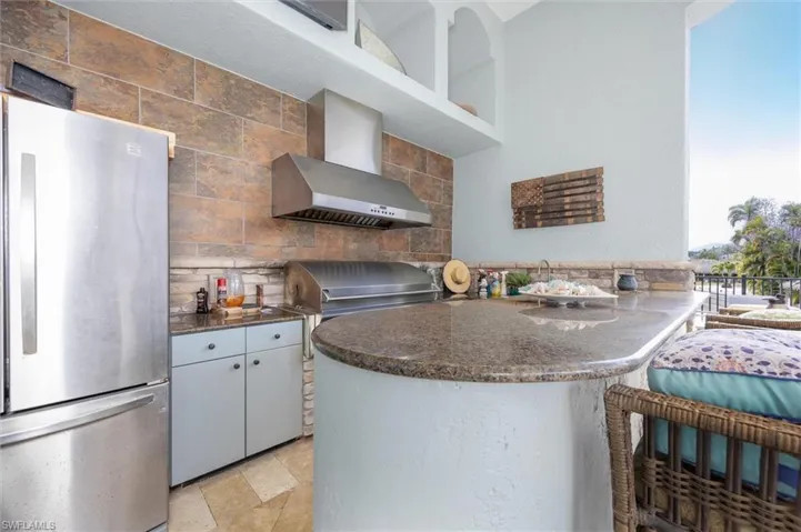 Outdoor kitchen with gas stove.  Granite countertops, flat screen TV.  Right by pool and dock.