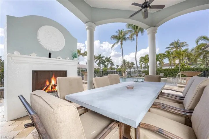 Table chairs off of outdoor kitchen with full fireplace