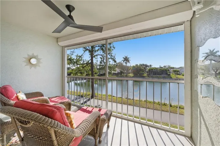 Living room featuring ceiling fan, wood finished floors, vaulted ceiling, and a water view