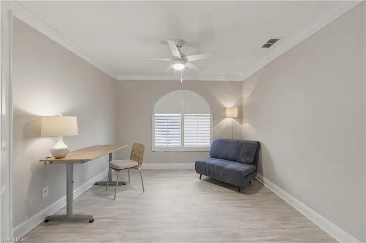 Home office with crown molding, ceiling fan, and light wood finished floors