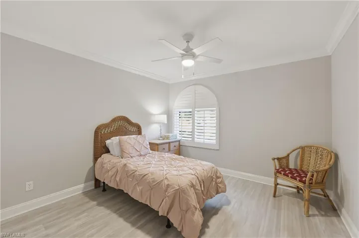 Bedroom featuring crown molding, light wood-type flooring, and ceiling fan