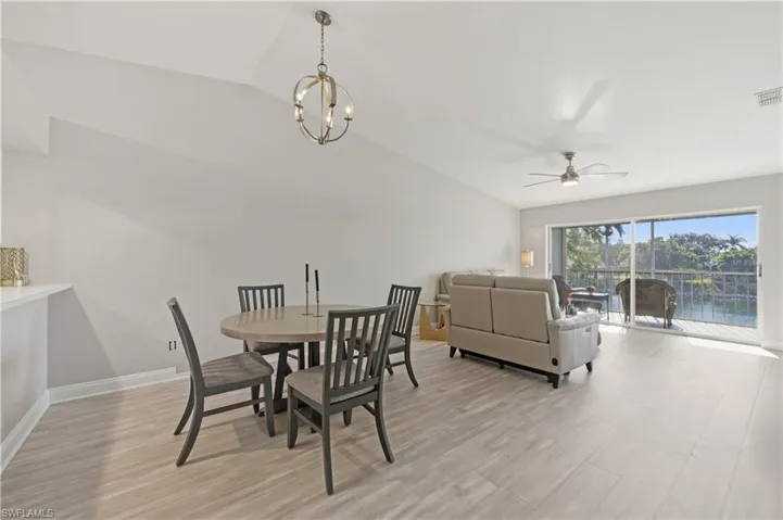 Dining area featuring ceiling fan, lofted ceiling, light wood-style floors, and suspended lighting