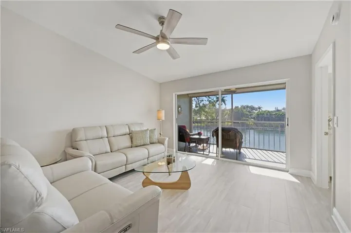 Living area with ceiling fan, a water view, a sunroom, and lofted ceiling