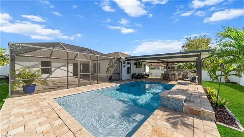 Rear view of house featuring a fenced backyard, a lanai, a sunroom, and a patio area