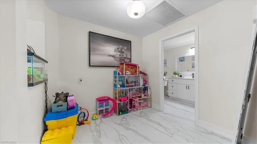Playroom featuring light marble finish floors and baseboards