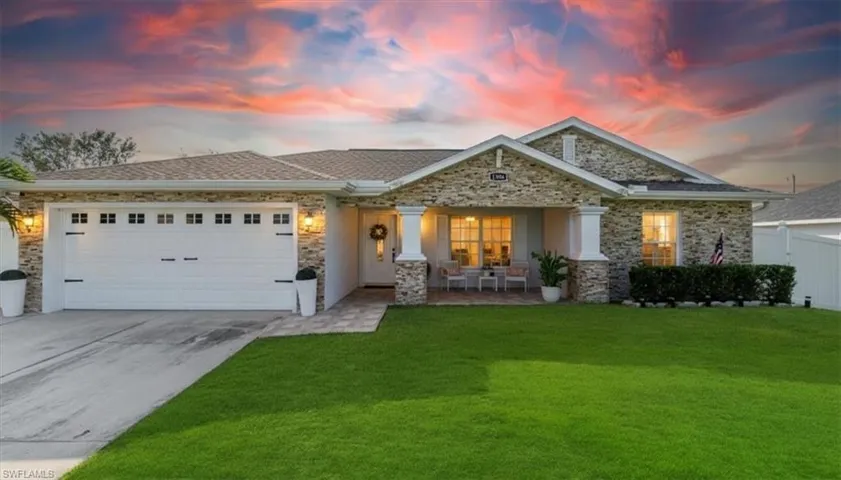 View of front facade featuring a garage, driveway, and a porch