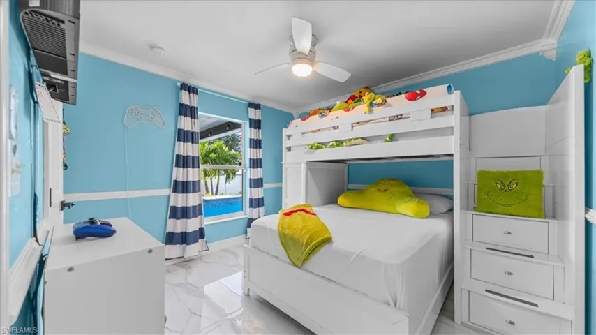 Bedroom with light marble finish floors, crown molding, and a ceiling fan