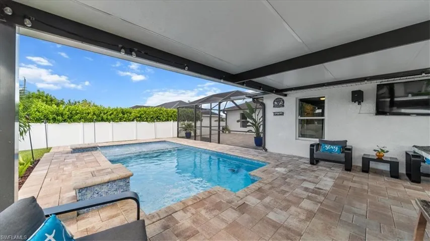 View of swimming pool with a sunroom, a patio area, glass enclosure, and a fenced backyard