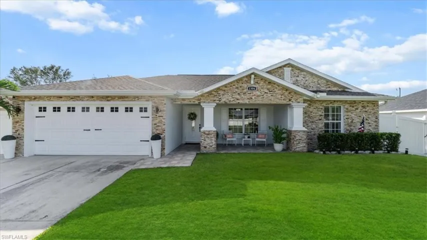 View of front of home featuring an attached garage, driveway, and a porch