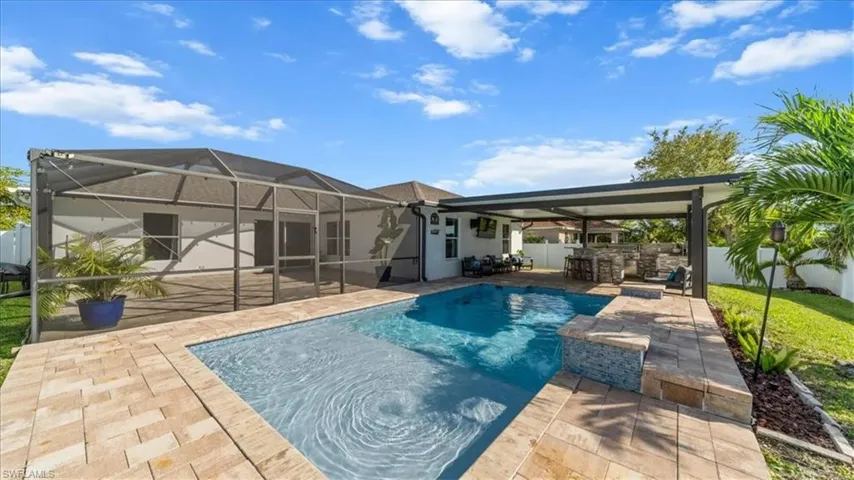 Rear view of property featuring a sunroom, a lanai, a fenced backyard, and a patio area