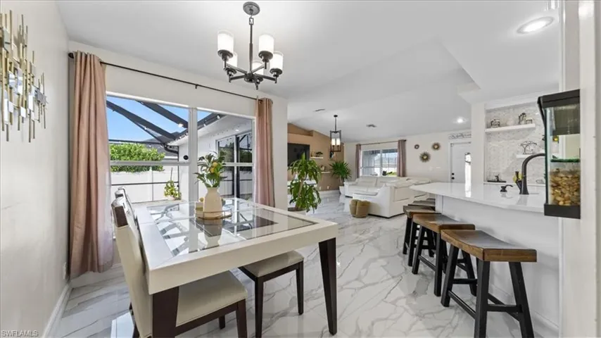 Dining area featuring light marble finish floors and a chandelier