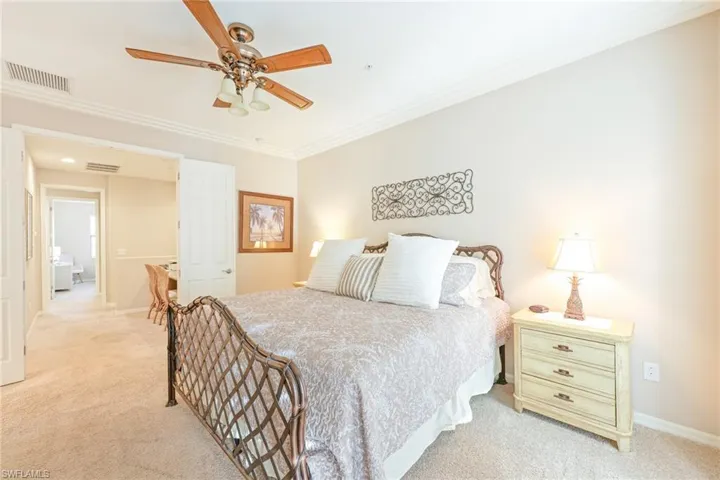 Bedroom featuring ceiling fan, light colored carpet, and crown molding