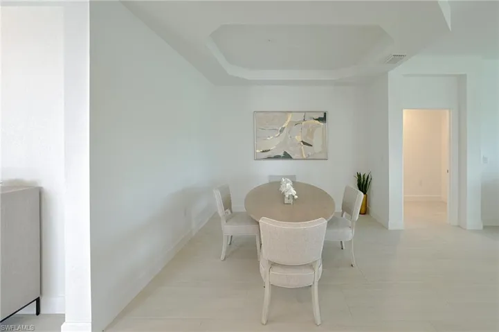 Dining area featuring a tray ceiling and baseboards
