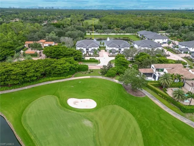 Aerial perspective of suburban area featuring a nearby body of water and a forest