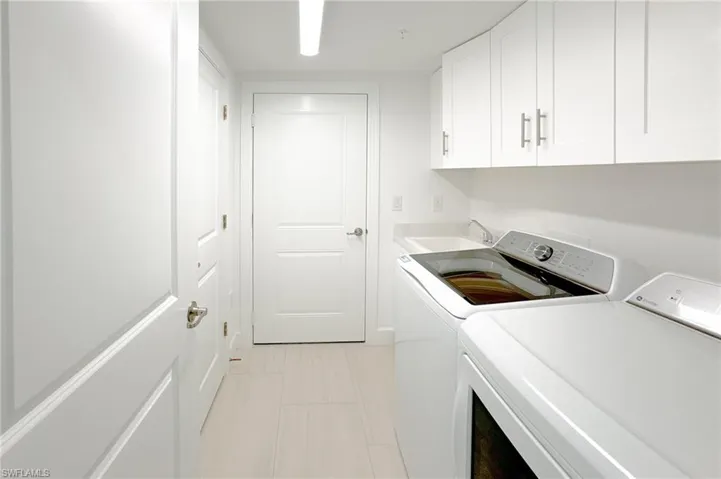 Laundry room with washing machine and clothes dryer and cabinet space