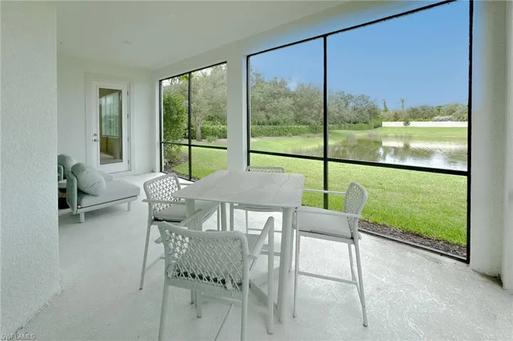 Sunroom / solarium with a water view and outdoor dining space