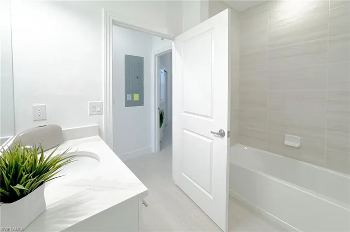 Full bath featuring vanity, electric panel, and bathtub / shower combination