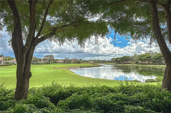 Surrounding community with a water view and a lawn